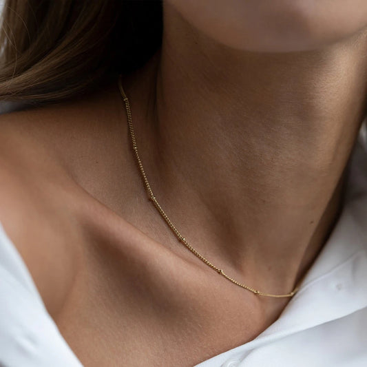 Colar dourado com pequenas pérolas