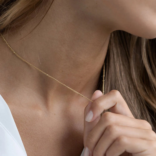 Colar dourado com pequenas pérolas